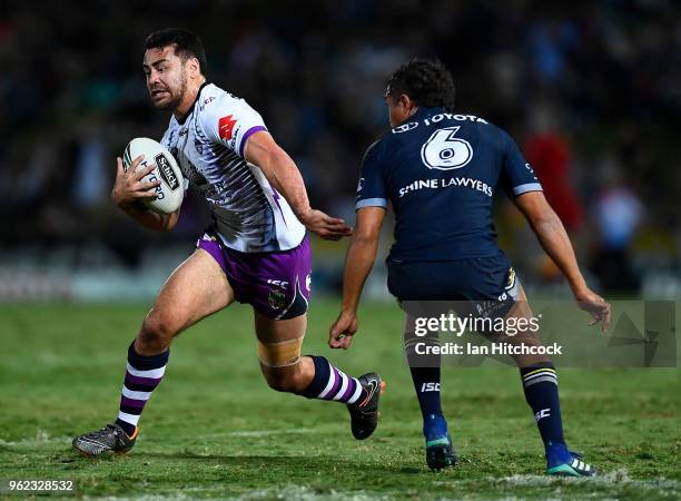 Jahrome Hughes of the Storm skips past Te Maire Martin of the Cowboys during the round 12 NRL match between the North Queensland Cowboys and the...