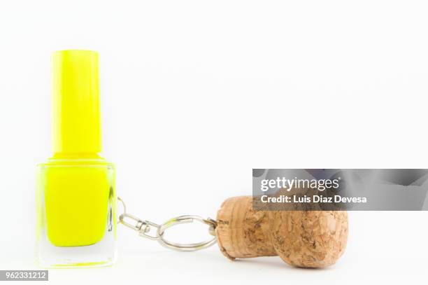 cava cork keyring holding  yellow nail polish - yellow nail polish stock-fotos und bilder