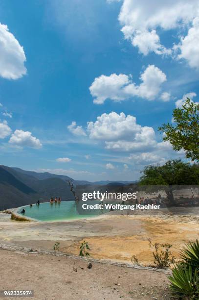 People bathing in the artificial pool filled with water from fresh water springs, whose water is over-saturated with calcium carbonate and other...