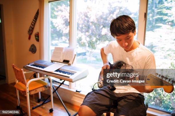 teenager practicing electric guitar at home - keyboard instrument stock pictures, royalty-free photos & images