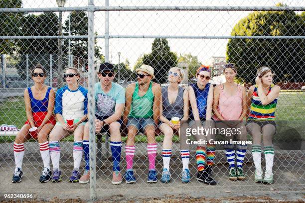 spectators sitting behind chainlink fence on field - striped socks stock pictures, royalty-free photos & images