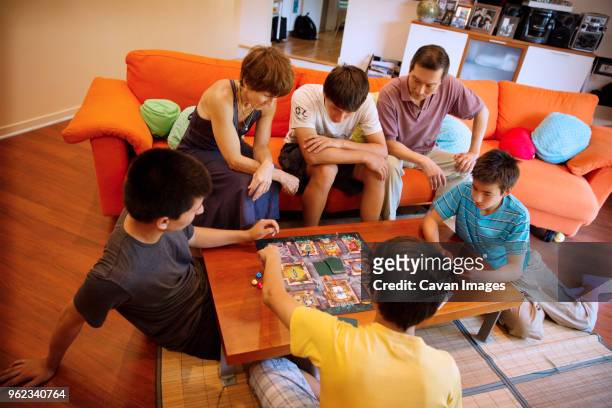 high angle view of family enjoying game in living room - 2014 asian games stock-fotos und bilder