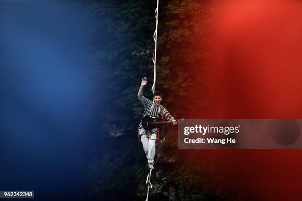 Frenchman Bastien Romero of the band HouleDouse perform on slacklines across the 1,400-meter-high cliffs of Tianmen Mountain on May 25,2018 in...