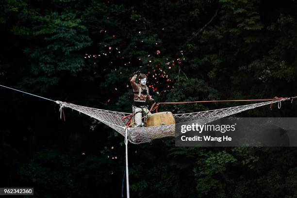 Frenchman David Farge of the band HouleDouse perform on slacklines across the 1,400-meter-high cliffs of Tianmen Mountain on May 25,2018 in...