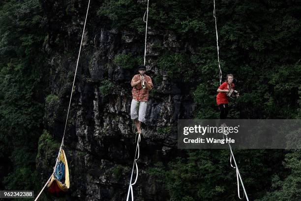 French?s Louise Lenoble and Belgium?s Daniel laruelle of the band HouleDouse perform on slacklines across the 1,400-meter-high cliffs of Tianmen...