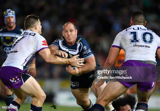 Matt Scott of the Cowboys is wrapped up by the Storm defence during the round 12 NRL match between the North Queensland Cowboys and the Melbourne...
