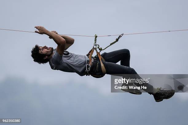 French's Guillaume Barrande of HouleDouse climb a slackline as he prepares to perform across the 1,400-meter-high cliffs of Tianmen Mountain on May...