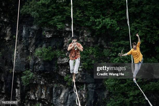 Daniel laruelle of Belgium with Frenchman Nicolas Pouchard of the band HouleDouse perform on slacklines across the 1,400-meter-high cliffs of Tianmen...