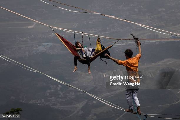 French 's Lucie Botiveau and Nicolas Pouchard of the band HouleDouse perform on slacklines across the 1,400-meter-high cliffs of Tianmen Mountain on...