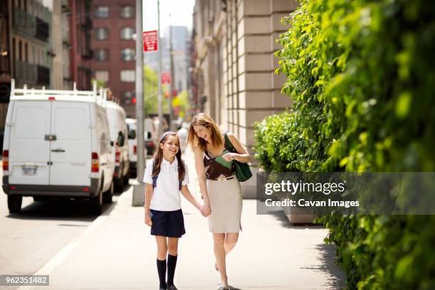 happy mother taking daughter off to school - parent daughter school uniform stock pictures, royalty-free photos & images