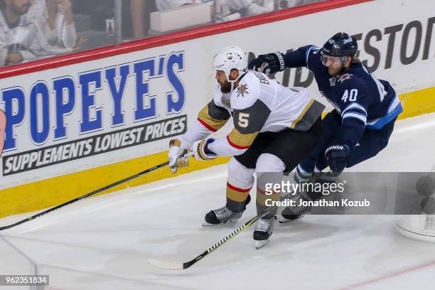 Deryk Engelland of the Vegas Golden Knights plays the puck along the boards as Joel Armia of the Winnipeg Jets gives chase during second period...