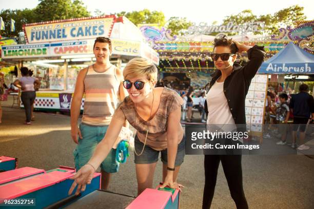 happy friends enjoying at amusement park arcade - fair game stock pictures, royalty-free photos & images