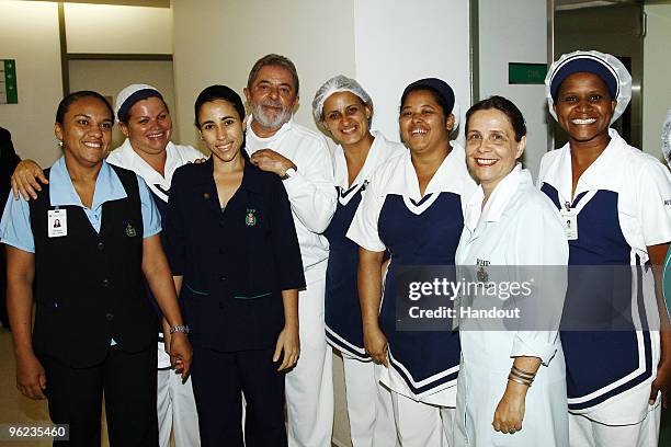 In this handout picture released by the Brazilian presidential office, Brazil's President Luiz Inacio Lula da Silva is seen posing with staff of the...