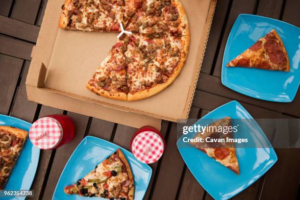 overhead view of pizza with blue plates and drinks on wooden table - takeaway box stock pictures, royalty-free photos & images