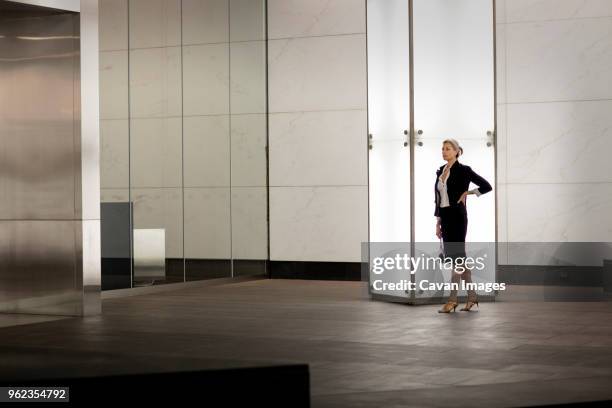 confident businesswoman standing by illuminated blank column in city - advertising column stock pictures, royalty-free photos & images