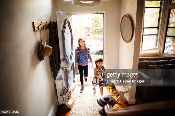 sisters entering home - family front door stock pictures, royalty-free photos & images