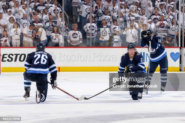 Blake Wheeler, Patrik Laine and Bryan Little of the Winnipeg Jets react following the final buzzer in a 2-1 loss against the Vegas Golden Knights in...