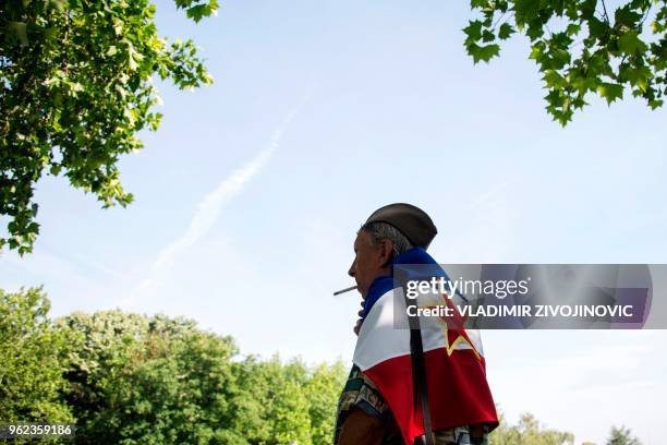 An admirer of the late Yugoslav Communist President Josip Broz Tito wears a flag of the former Communist state in front of his memorial complex in...