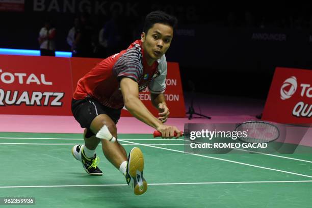 Anthony Sinisuka Ginting of Indonesia hits a return against Chen Long of China during their men's singles semifinals match at the Thomas and Uber Cup...
