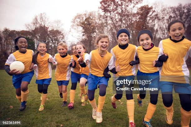 excited female soccer team enjoying on playing field - football team stock pictures, royalty-free photos & images