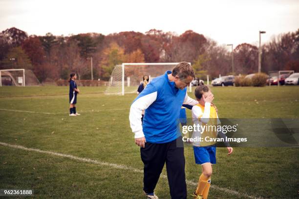 coach consoling soccer player on field at match - sad football player stock pictures, royalty-free photos & images