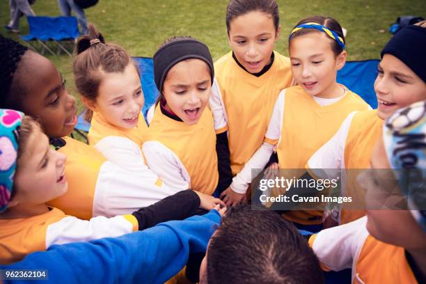 soccer players huddling during match - young girl soccer stock pictures, royalty-free photos & images