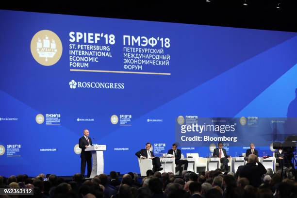 Vladimir Putin, Russia's president, left, speaks at the plenary session with, from left to right, John Micklethwait, editor-in-chief at Bloomberg...