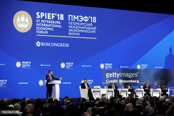 Emmanuel Macron, France's president, left, speaks as, from left to right, John Micklethwait, editor-in-chief at Bloomberg News, Vladimir Putin,...