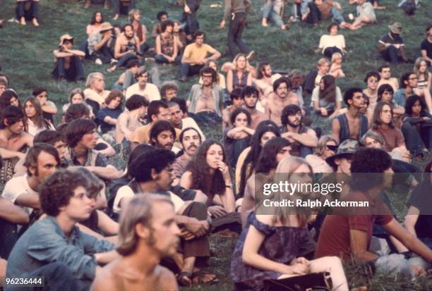 View of a portion of the audience as they watch a performance at the Woodstock Music and Arts Fair, Bethel, New York, August 1969. The festival ran...