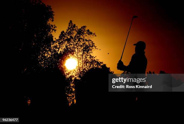 Paul Casey of England watches his second shot in to the par five 18th hole as the sun sets at the end of the first round of The Commercialbank Qatar...
