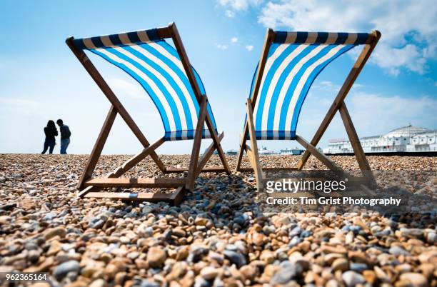 silhouette of young couple and two empty deck chairs and the palace pier, brighton - palace pier fotografías e imágenes de stock