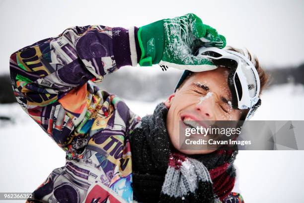 cheerful man on snow covered field - goggles sportswear stock pictures, royalty-free photos & images