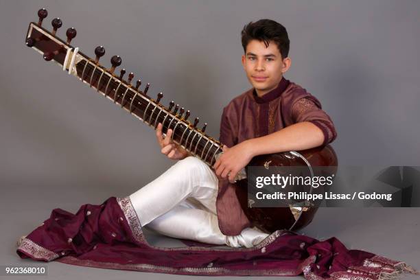 teenager playing a sitar. paris, france. - sitar photos et images de collection