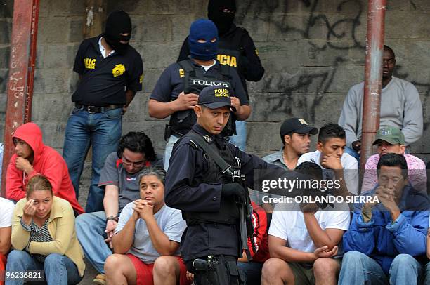 Policeman shows detainees to the press after a security operation in which arms including an RPG-7 grenade launcher were seized in the outskirts of...