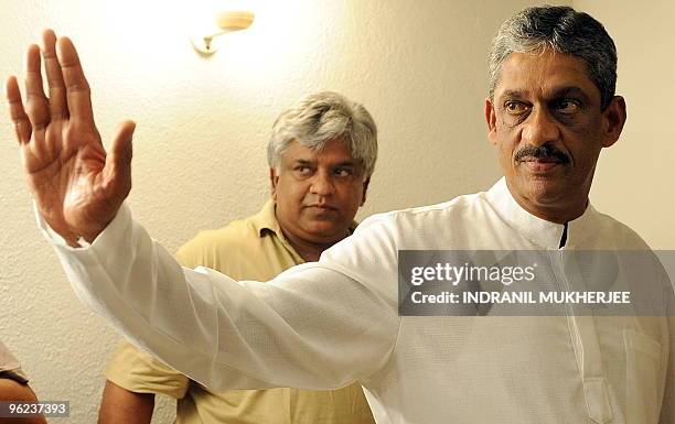 Former Sri Lankan cricketer Arjuna Ranatunga looks on as former army chief and beaten presidential candidate General Sarath Fonseka waves to the...