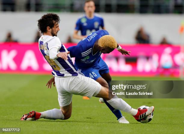 Mijusko Bojovic of Ujpest FC slide tackles Ezekiel Henty of Puskas Akademia FC during the Hungarian Cup Final match between Puskas Akademia FC and...