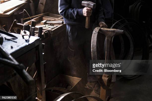 Cooper uses a mallet and anvil to secure hoop rivets for a wine barrel ahead of the grape harvest season and port production at the Symington-Family...