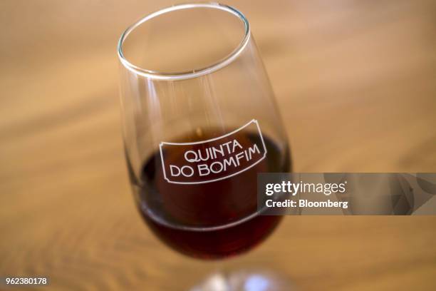 Glass of Dow's Quinta do Bomfim Port, produced by Symington-Family Estates Vinhos Lda, rests on a table in the Douro Valley grape growing region in...
