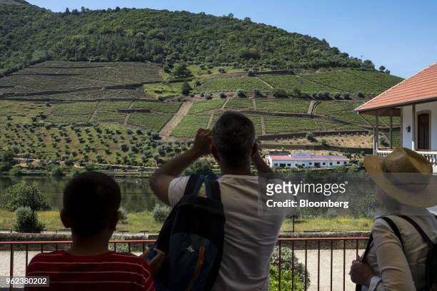 Tourists look towards the Quinta do Bomfim vineyards on the slopes of the Douro Valley grape growing region in Alijo, Portugal, on Tuesday, May 22,...