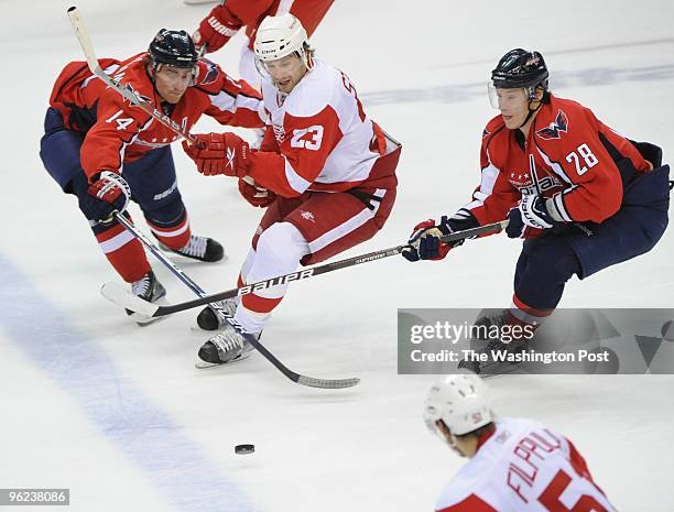 January 19: Washington Capitals center Tomas Fleischmann , left, and Washington Capitals left wing Alexander Semin , right, try to steal the puck as...