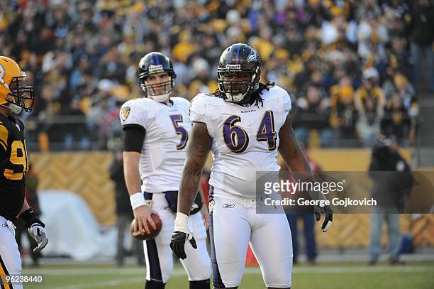 Offensive lineman Oniel Cousins of the Baltimore Ravens looks on from the field while standing near quarterback Joe Flacco during a game against the...