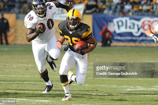 Running back Willie Parker of the Pittsburgh Steelers is pursued by defensive lineman Trevor Pryce of the Baltimore Ravens as he runs the football...