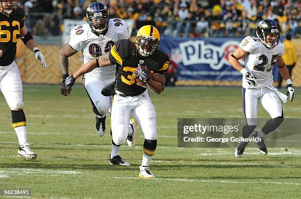 Running back Willie Parker of the Pittsburgh Steelers is pursued by defensive lineman Trevor Pryce of the Baltimore Ravens as he runs the football...