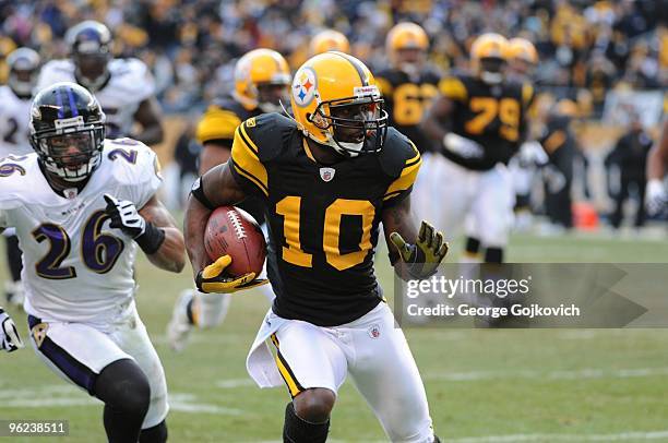 Wide receiver Santonio Holmes of the Pittsburgh Steelers scores a touchdown on a 24-yard pass play as he is pursued by defensive back Dawan Landry of...