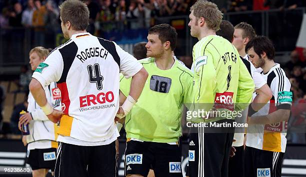 Oliver Roggisch, Michael Kraus and Johannes Bitter of Germany look dejected after the Men's Handball European main round Group II match between...
