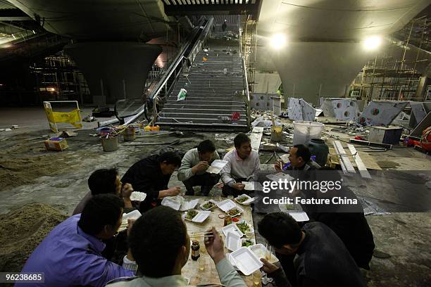 Migrants take a break from working to complete Guangzhou South Railway Station on 25 January, 2010 in Guangzhou, Guangdong province, China. Part of...