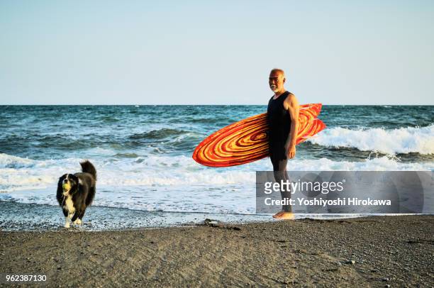senior surfer at beach with dog - chigasaki stock pictures, royalty-free photos & images