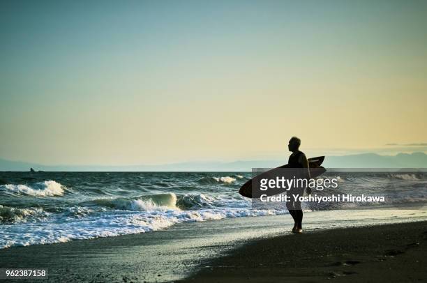 silhouette of senior surfer - chigasaki stock pictures, royalty-free photos & images
