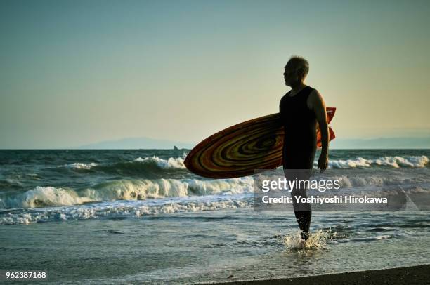silhouette of senior surfer - chigasaki stock pictures, royalty-free photos & images