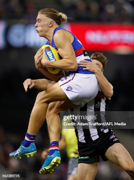 Roarke Smith of the Bulldogs marks the ball ahead of Josh Thomas of the Magpies during the 2018 AFL round 10 match between the Collingwood Magpies...